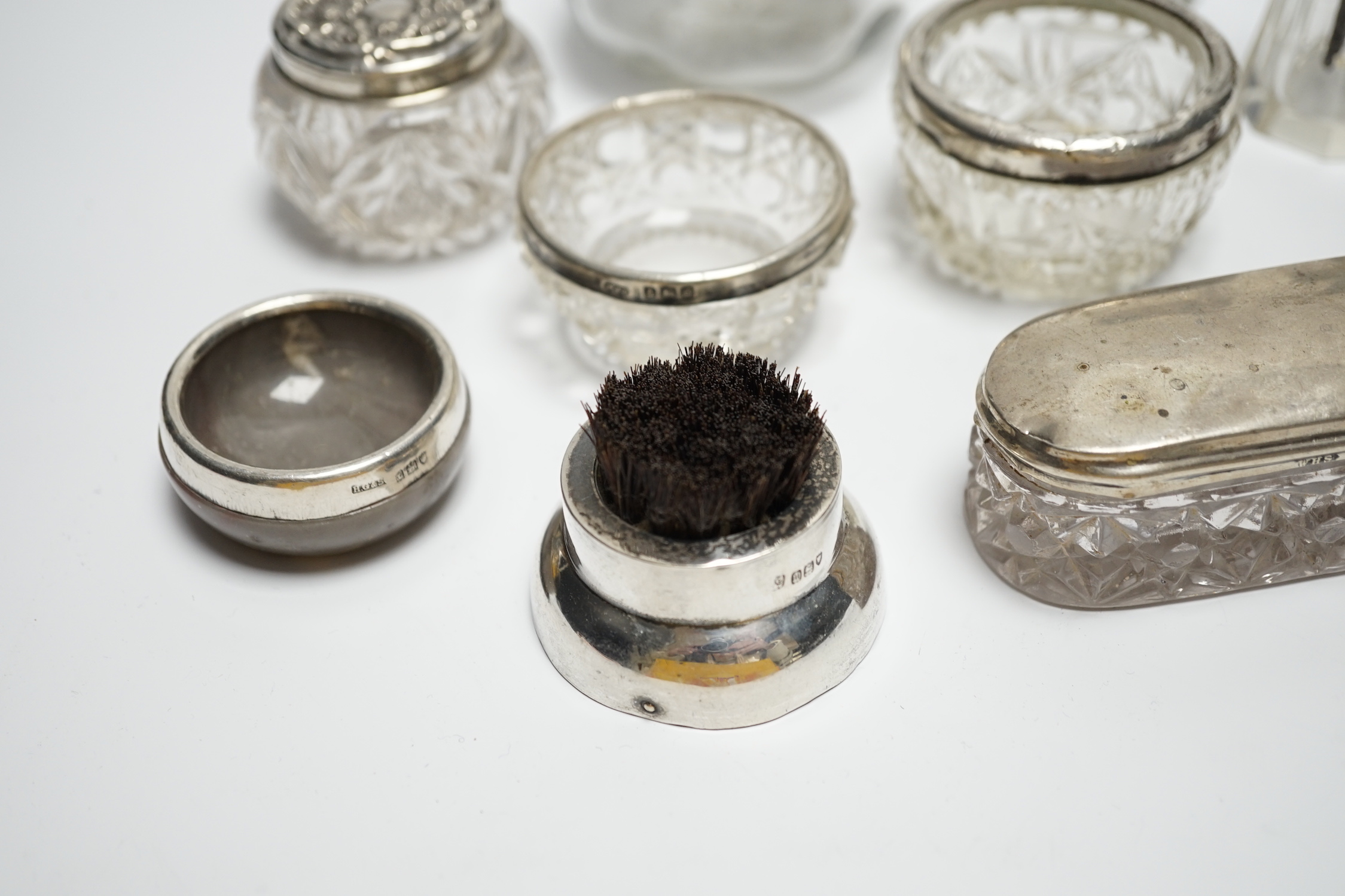 Eight assorted silver topped toilet jars, etc. a silver mounted nail buffer and pen wipe.